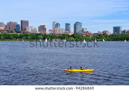 Boston Charles River with urban city skyline skyscrapers and boats with blue sky over Charles River.