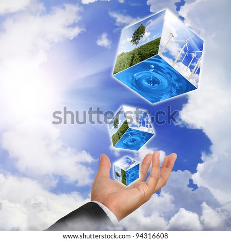 Business man hand holding with nature water drop and wind  turbines farm on sky