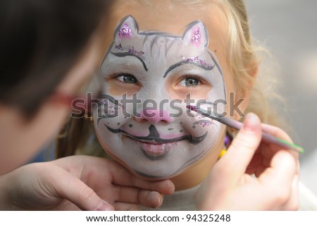 Little girl with painting face as a cat Royalty-Free Stock Photo #94325248