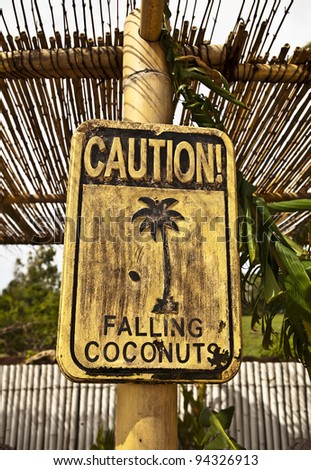 Old funny wooden caution sign on the beach.