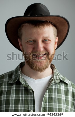 The good-natured cowboy hat and a green plaid shirt Royalty-Free Stock Photo #94342369