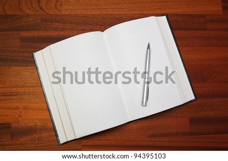 Open notebook and pen on a wooden table