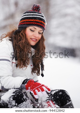 Beautiful young woman portrait, dressed casually outdoor in winter playing in the snow.