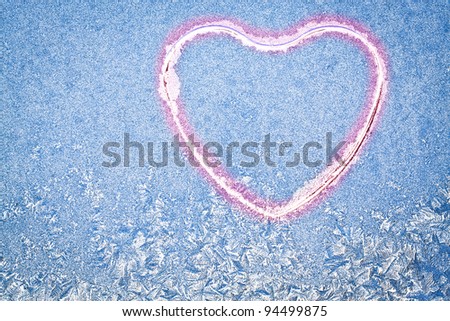 Snowflakes at a window in the form of heart