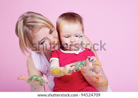 Child playing with color paints