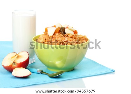 tasty cornflakes in bowl with dried fruits, glass of milk and apple on blue napkin