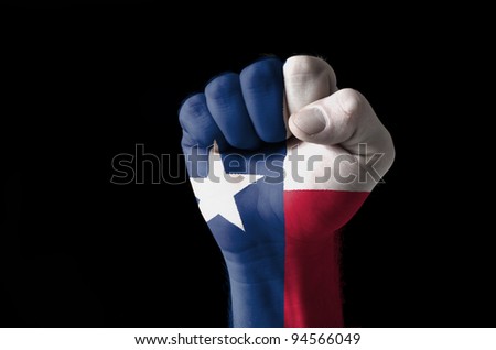Low key picture of a fist painted in colors of american state flag of texas