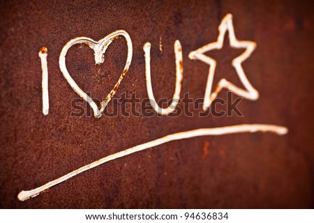 Old love will not be forgotten.  Text I love U star painted on the old rusty door. Shallow deep of focus.