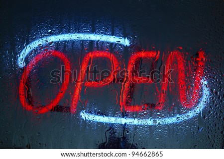 Colorful neon open sign seen through a rainy night