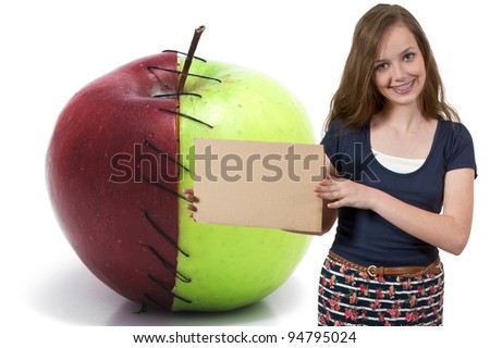 A beautiful young teenager woman holding up a blank sign by a sweet and sour apple