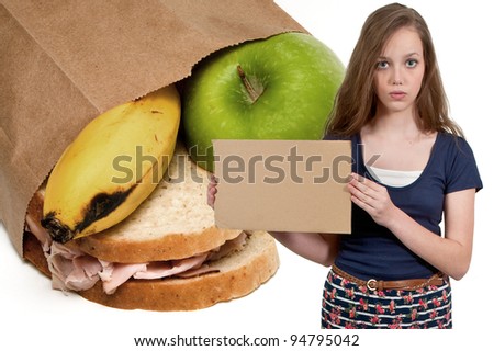 A beautiful young teenager woman holding up a blank sign buy a bag lunch