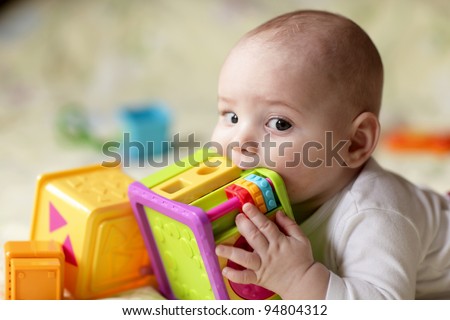 The boy biting a toy on a bed at home Royalty-Free Stock Photo #94804312