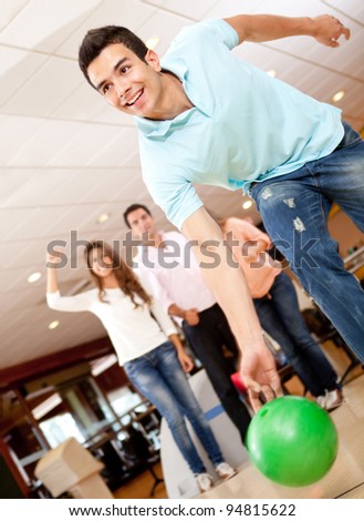 Man bowling and his friends cheering at the background