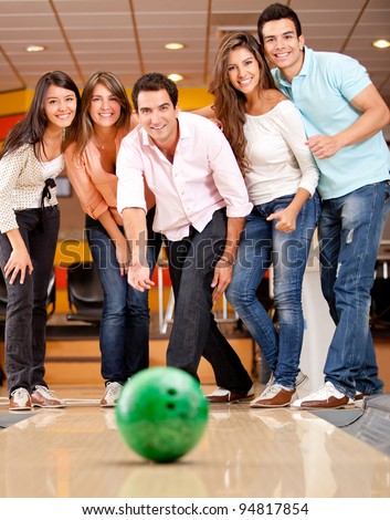Happy group of friends having fun bowling