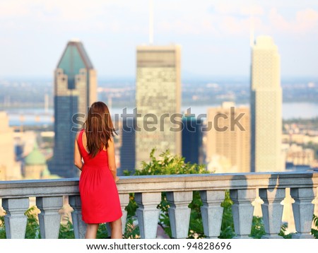 Montreal. Woman looking at Montreal downtown skyline cityscape. Tourist girl in red dress on Mont Royal in spring or summer.