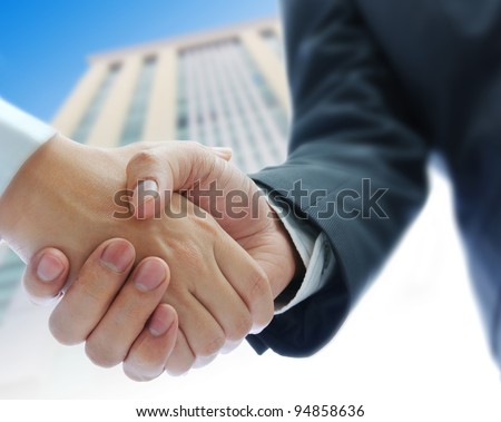 business people shaking hands  building background Royalty-Free Stock Photo #94858636