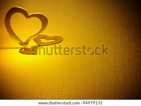 Three gold hearts on a gold background.