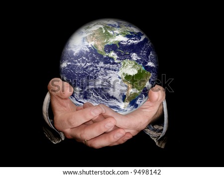 Hands holding an earth planet against a black isolated background