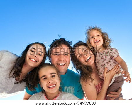 Group of happy smiling friends: man, women and kids having fun outdoors against blue sky background. Summer vacations concept Royalty-Free Stock Photo #94997839