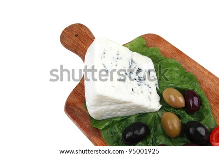 stilton cheese on wooden platter with olives and tomato isolated over white background