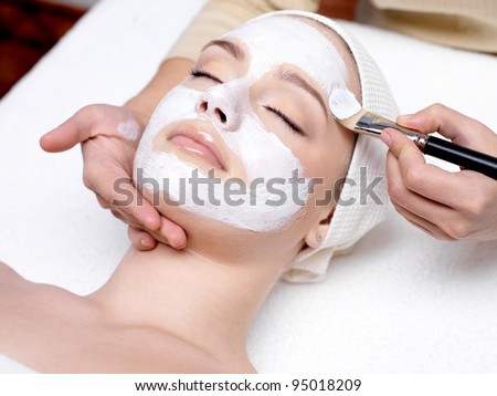 Beautiful woman with facial mask at beauty salon Royalty-Free Stock Photo #95018209
