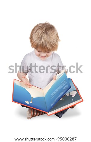 Young blonde 4 or 5 year old boy reading a picture book