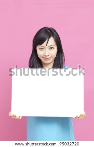 Young woman holding blank billboard.