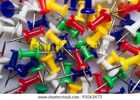 A macro background image of mixed colorful thumbtacks