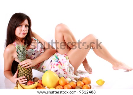 Girl with a lot of different fruits - from pineapple till kiwi and oranges