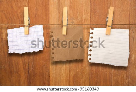 close up of a notes and a clothes pegs on wood wall