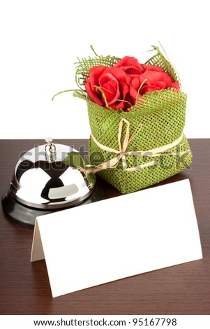 Service Bell with Blank Sign and red roses at Hotel Desk
