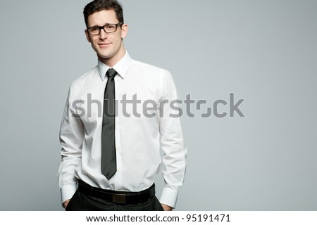 Young handsome businessman in white shirt on gray background.