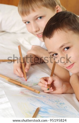 happy boys drawing a pencils on the floor together