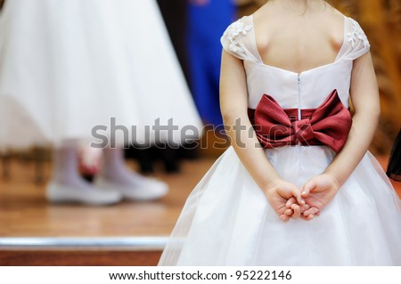 Beautiful red bow on flower-girl's dress Royalty-Free Stock Photo #95222146