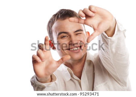 Portrait of smiling young man making frame with finger against white background