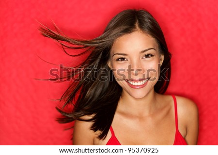 beauty woman happy. Beautiful fresh multiracial girl smiling fresh and natural on red background. Multicultural Caucasian / Chinese Asian young woman model.