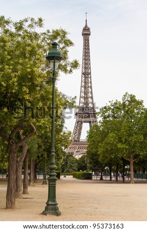 Eiffel Tower in the background with lamppost in foreground and basketball players