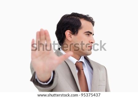 Close up of salesman signalizing stop against a white background