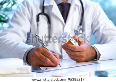 Doctor writing out RX prescription selective focus Royalty-Free Stock Photo #95385217