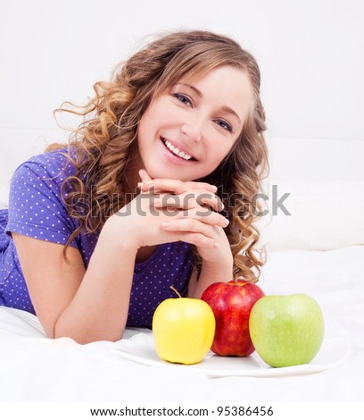 happy beautiful woman with apples in bed at home