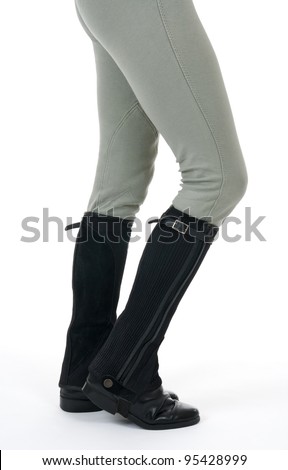 Woman wearing horse riding boots and breeches, on white background.