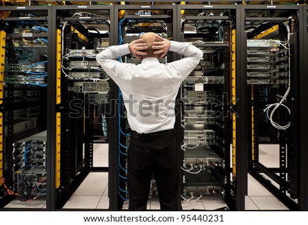Man looking astonished in a network data center. Royalty-Free Stock Photo #95440231