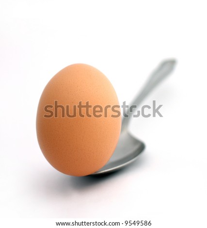 egg balancing on a spoon on a white background