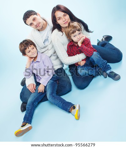 Cute happy family of a four in the studio