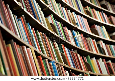 Bookshelf in library with many books. Shallow dof.