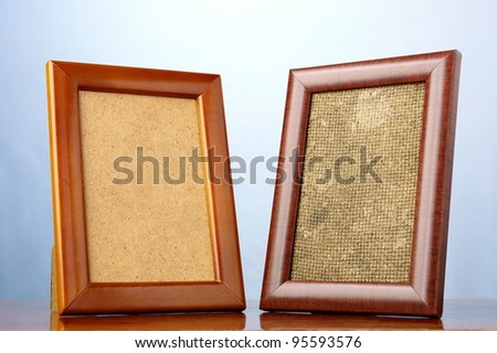 two wooden frames for pictures on a blue background