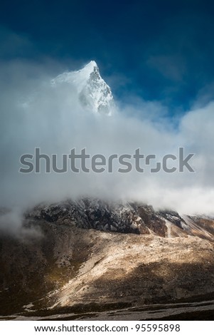 Cholatse 6335 m mountain summit hidden in clouds. Pictured in Nepal