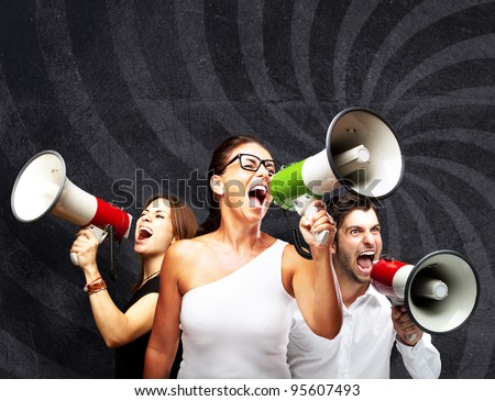 people shouting with megaphone against a grunge wall