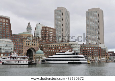 view from the dock at boston harbor and rowes wharf and skyscraper buildings in boston massachusetts