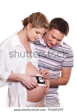 Happy pregnant family with ultrasound picture of their future baby on a white background.
